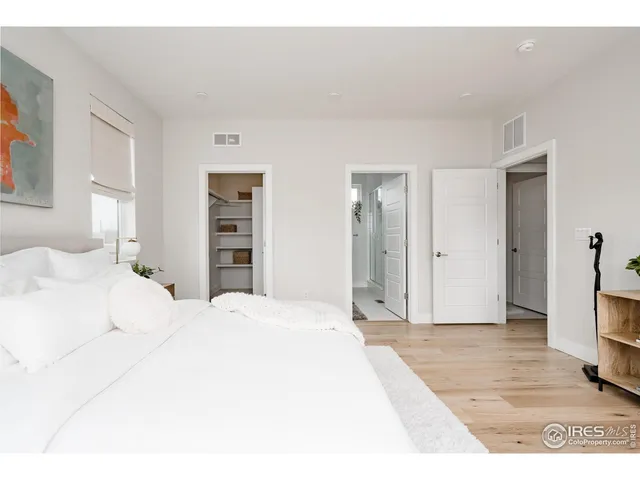 a bedroom with a large bed and a potted plant