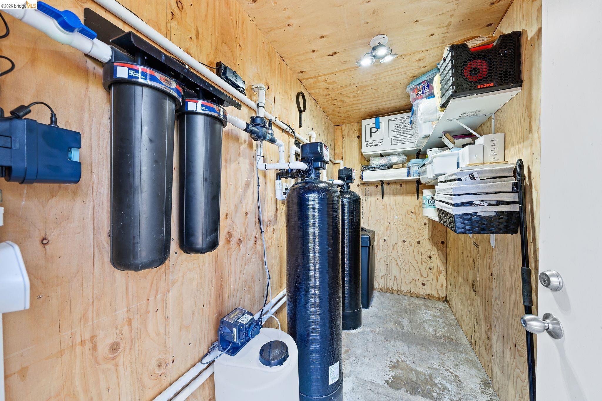 1704 Taylor Road Bethel Island, CA 94511 - Photo 61 of 73 Dedicated utility room featuring wood-finish wall paneling, a concrete floor, and multiple water filtration systems