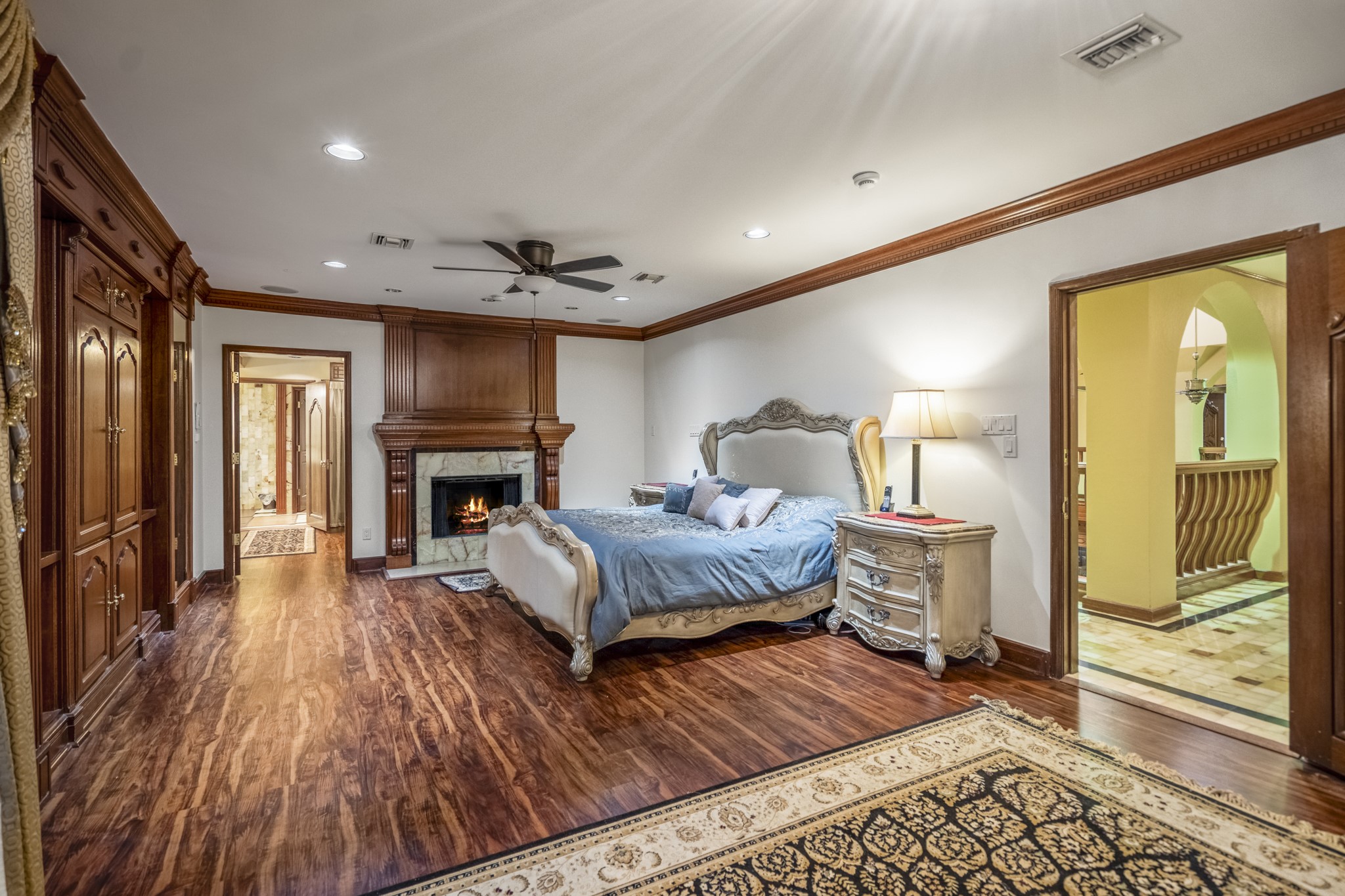 6535 Buffalo Speedway Houston, TX 77005 - Photo 20 of 34 The serene primary suite offers a spacious layout with warm luxury vinyl plank flooring, carved wood details, and room for a private seating area or reading nook.