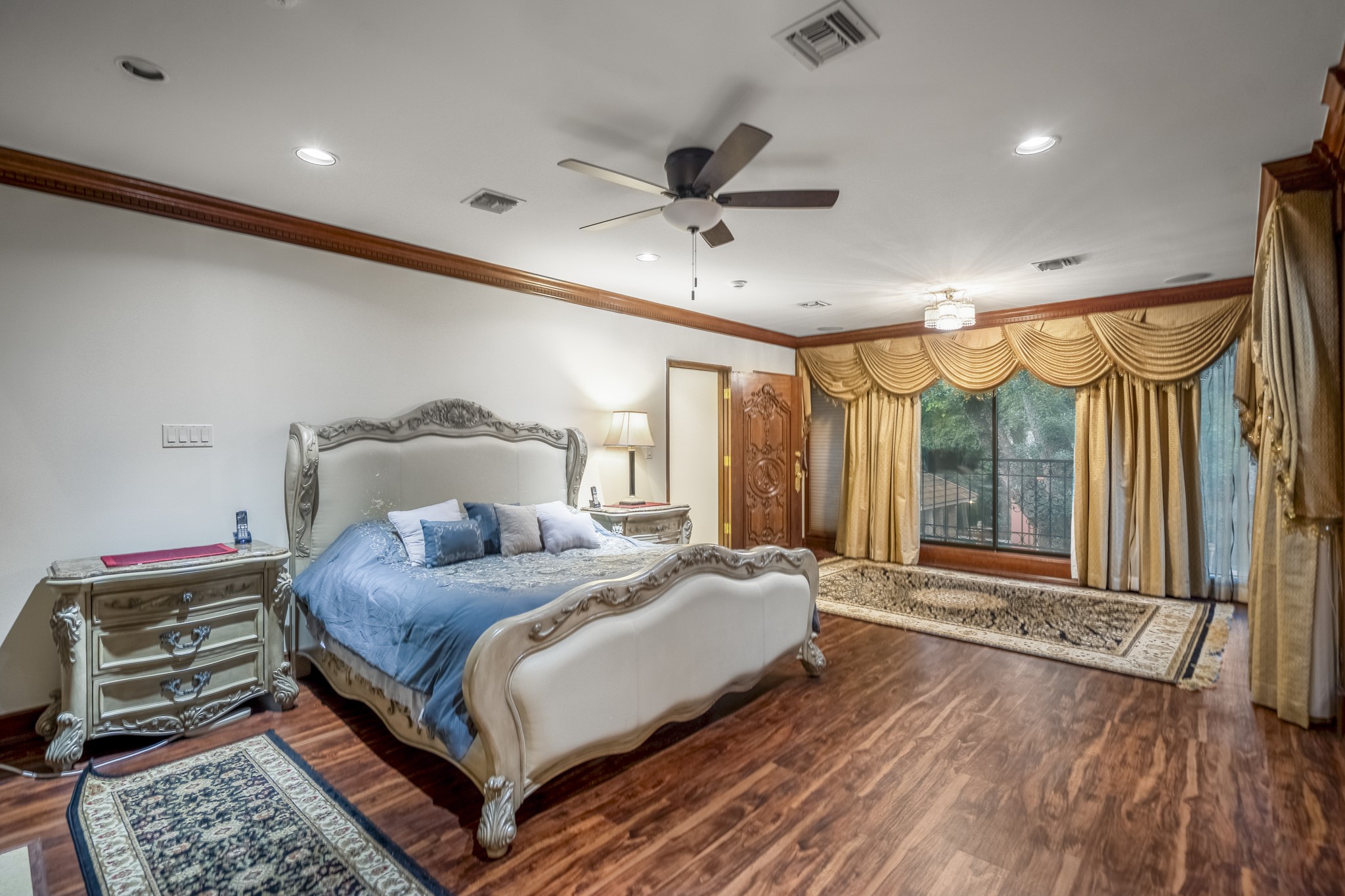 6535 Buffalo Speedway Houston, TX 77005 - Photo 21 of 34 A different angle of the primary bedroom reveals its scale and comfort, with richly textured finishes and tranquil backyard views through large windows.