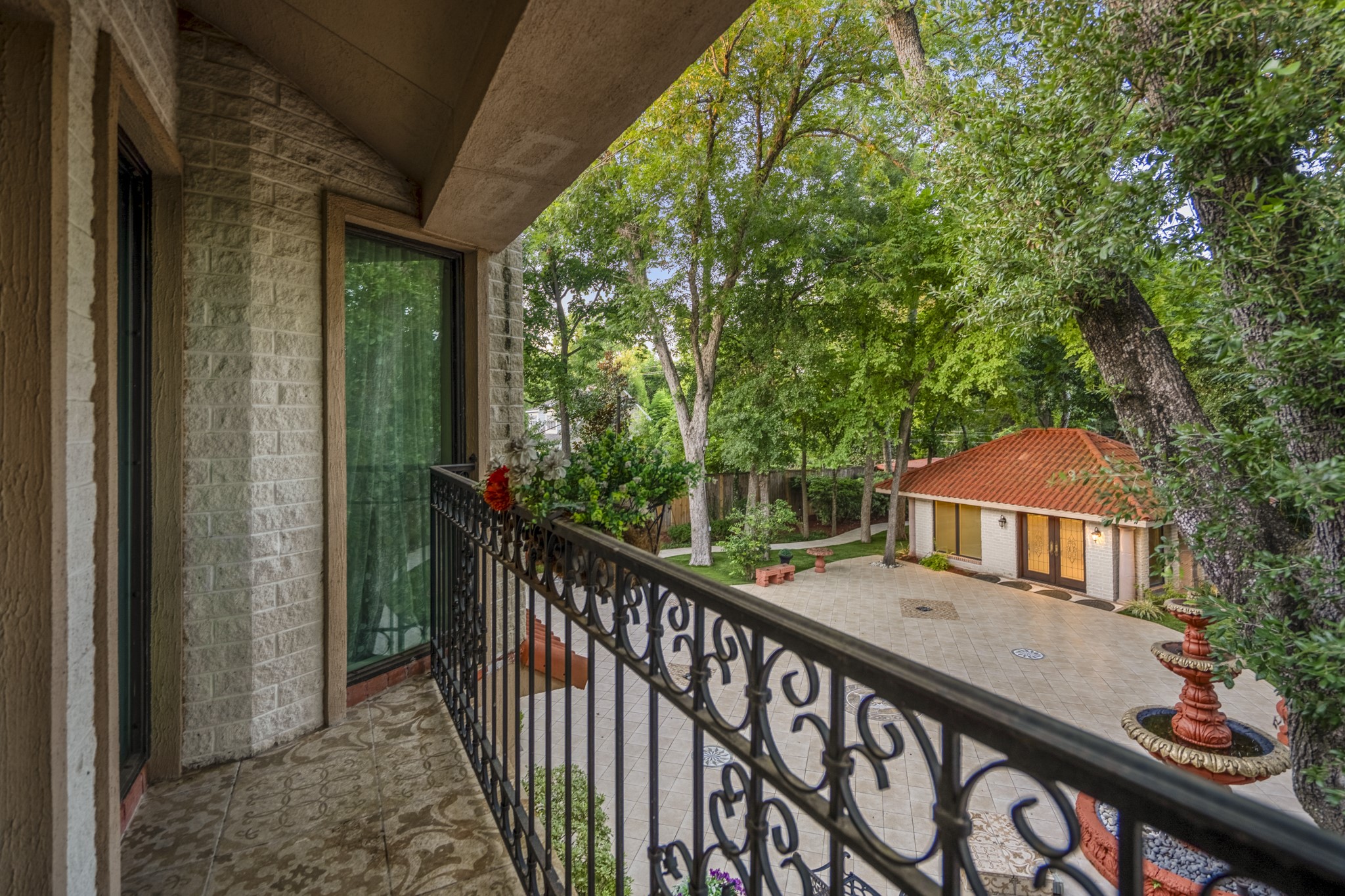 6535 Buffalo Speedway Houston, TX 77005 - Photo 22 of 34 Step from the primary suite onto a private balcony with intricate tile underfoot and leafy views, creating a peaceful outdoor extension of your retreat.