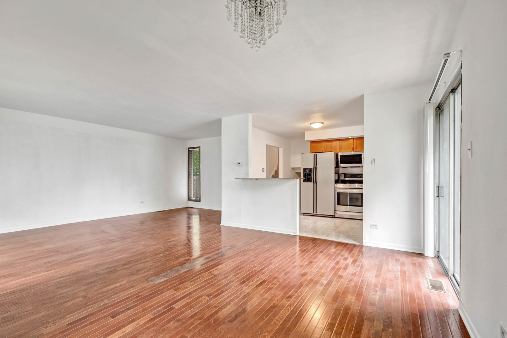 18932 Springfield Avenue Flossmoor, IL 60422 - Photo 5 of 22 a view of empty room with wooden floor and kitchen