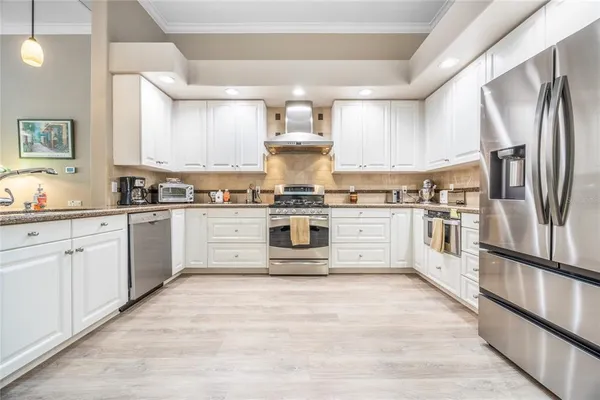 a kitchen with stainless steel appliances granite countertop a stove top oven and refrigerator