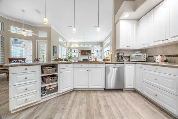 a kitchen with cabinets stainless steel appliances and a window
