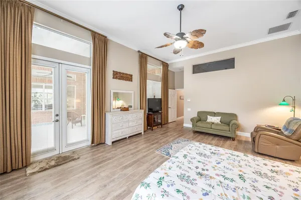 a bedroom with a large bed a flat tv screen and dresser