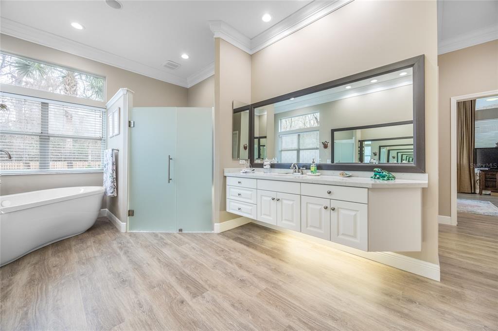 5922 Northwest 72 Street Gainesville, FL 32653 - Photo 32 of 52 a spacious bathroom with a double vanity sink a large mirror and a bathtub