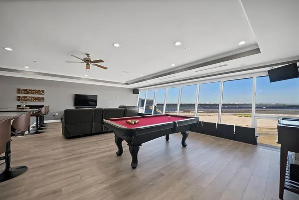 a room with furniture pool table flat screen tv and windows