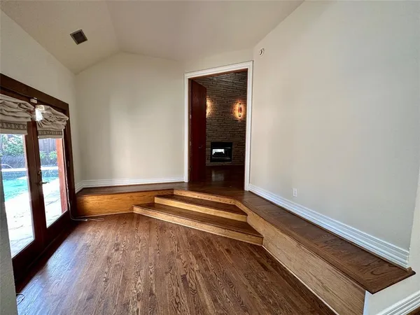 an empty room with wooden floor and a window