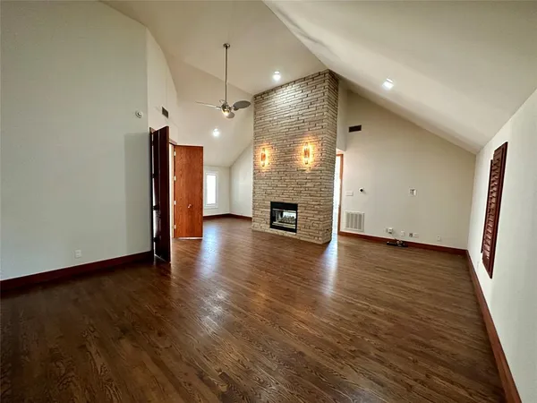 a view of a livingroom with wooden floor and a fireplace