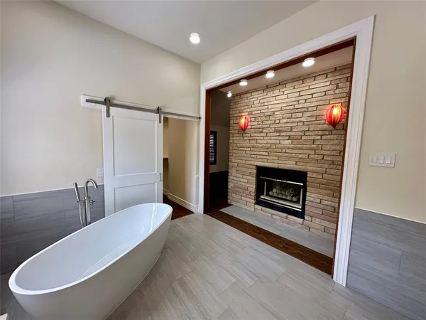 a spacious bathroom with a granite countertop sink toilet a mirror and a tub