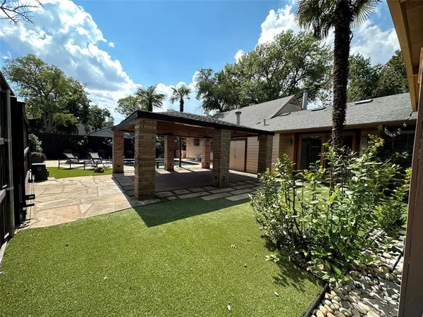 a view of a house with backyard and sitting area