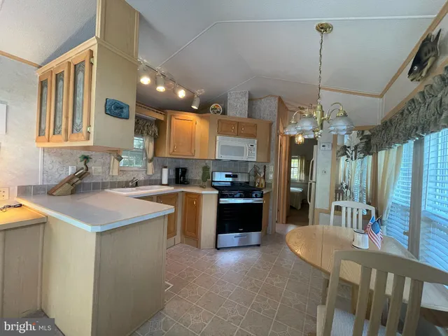 a kitchen with kitchen island granite countertop a sink a counter top space and stainless steel appliances
