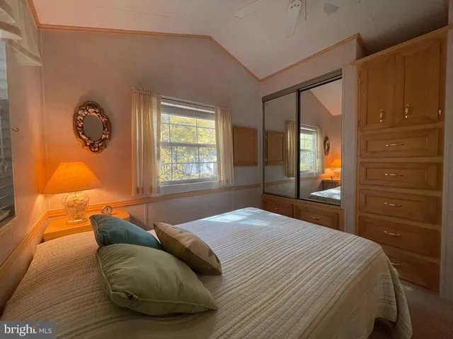 a bedroom with a bed and a dresser next to a window