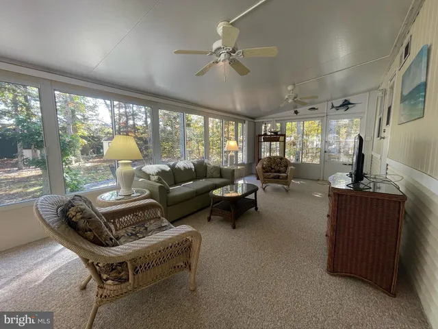 a living room with furniture gym equipment and large windows
