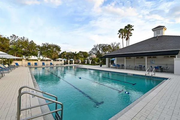 a view of a house with pool and chairs