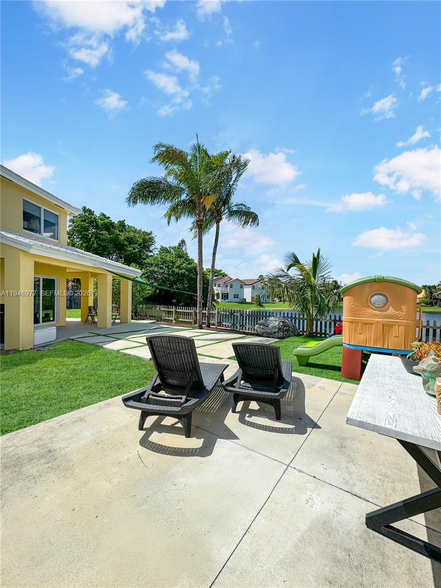 15481 Southwest 47th Terrace, Unit 15481 Miami, FL 33185 - Photo 13 of 29 a view of a patio with a table chairs and a fire pit