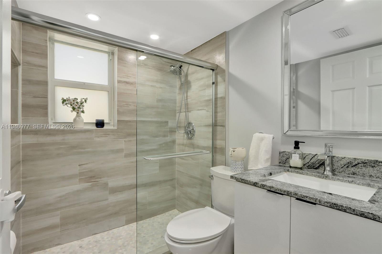 15481 Southwest 47th Terrace, Unit 15481 Miami, FL 33185 - Photo 20 of 29 a bathroom with a granite countertop sink a toilet and shower