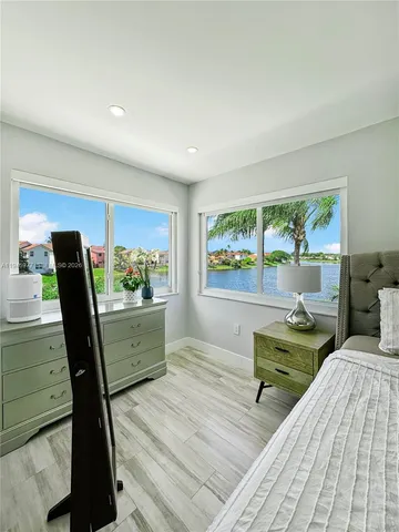 a view of a workspace room with wooden floor and furniture