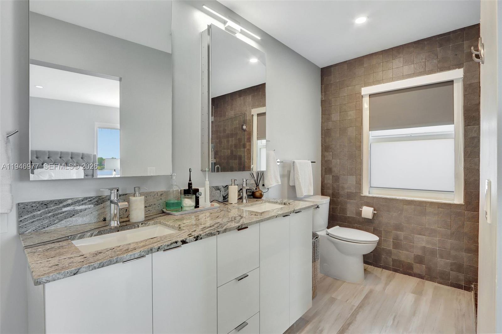15481 Southwest 47th Terrace, Unit 15481 Miami, FL 33185 - Photo 24 of 29 a bathroom with a granite countertop sink a toilet and mirror