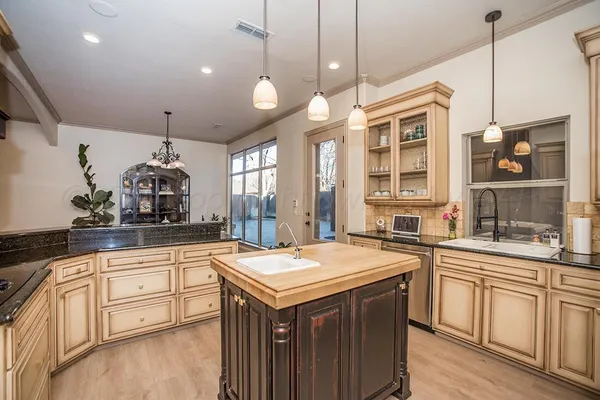 a kitchen with stainless steel appliances granite countertop a sink and a refrigerator