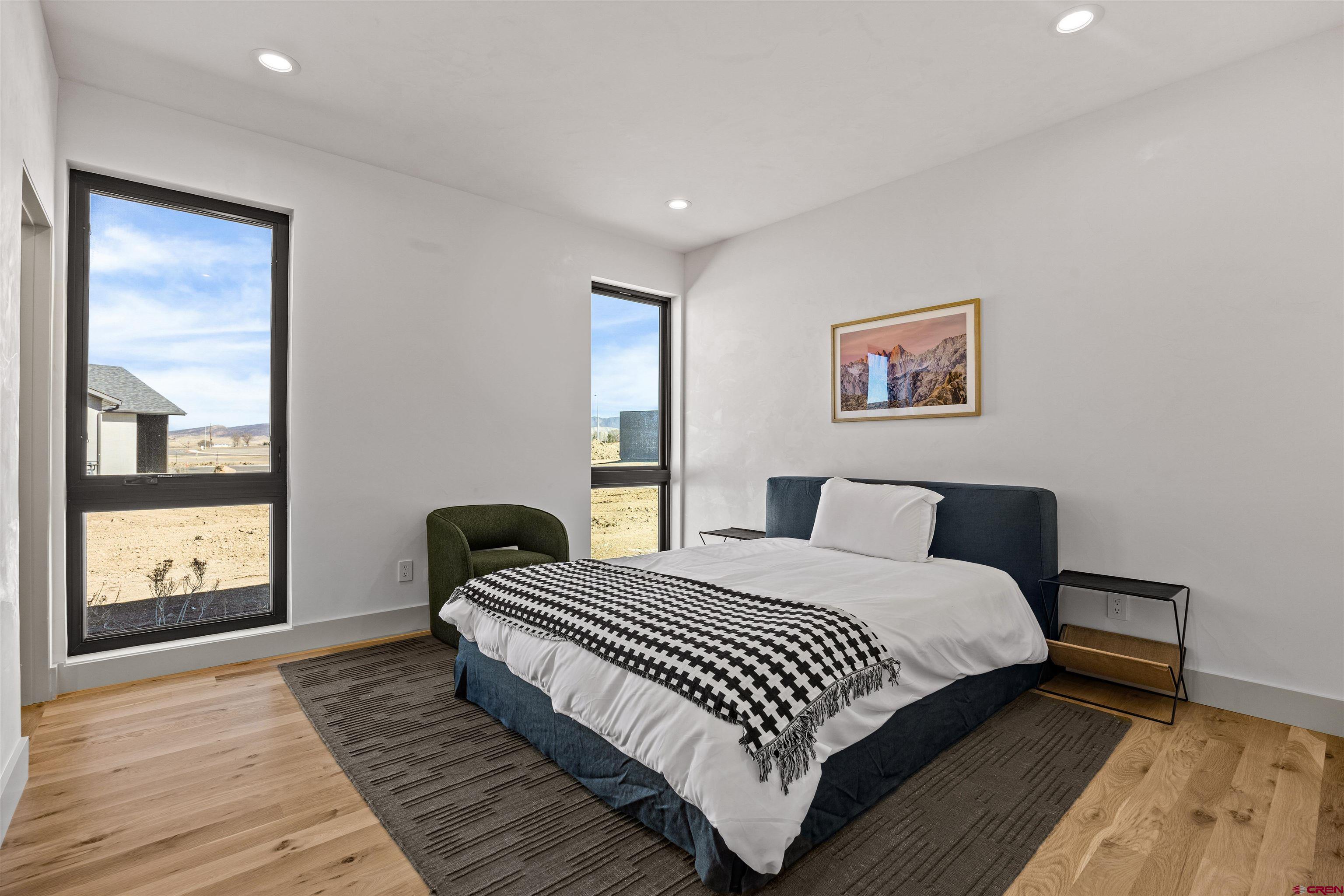3435 Kestrel Loop Montrose, CO 81401 - Photo 19 of 34 a bedroom with a bed and wooden floor