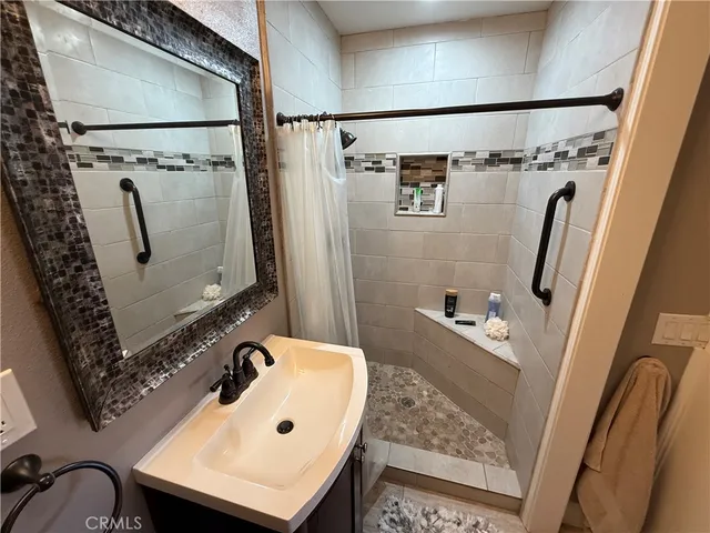 a bathroom with a sink and mirror with bathtub
