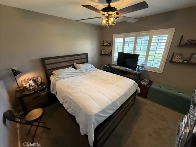 a bedroom with a bed and a tv on dresser