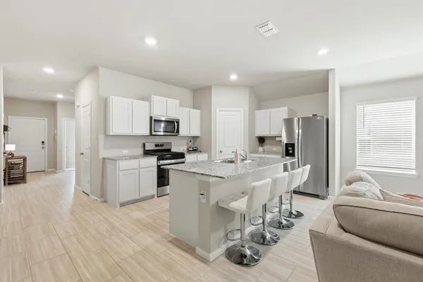 a kitchen with stainless steel appliances kitchen island granite countertop a sink and cabinets