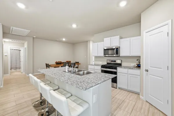 a kitchen with granite countertop kitchen island wooden cabinets and stainless steel appliances
