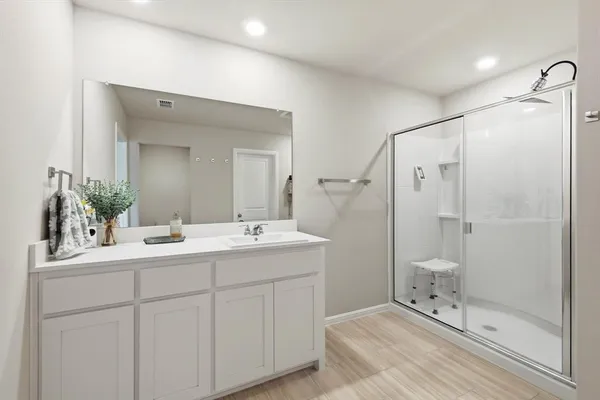 a en suite bathroom with a double vanity sink mirror and shower