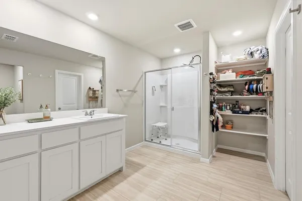 a bathroom with a shower sink and mirror