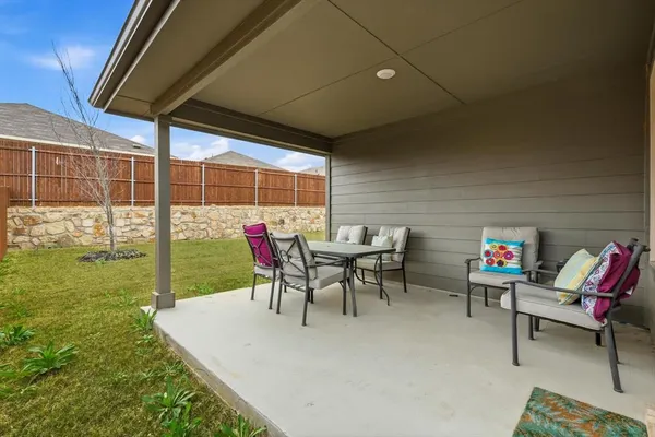 a view of a tables and chairs in patio next to a yard