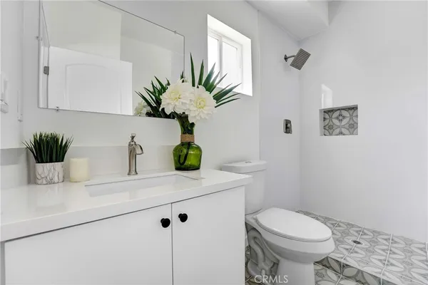 a bathroom with a sink a toilet and a mirror