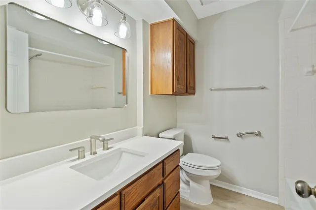 a bathroom with a toilet a sink a mirror and vanity