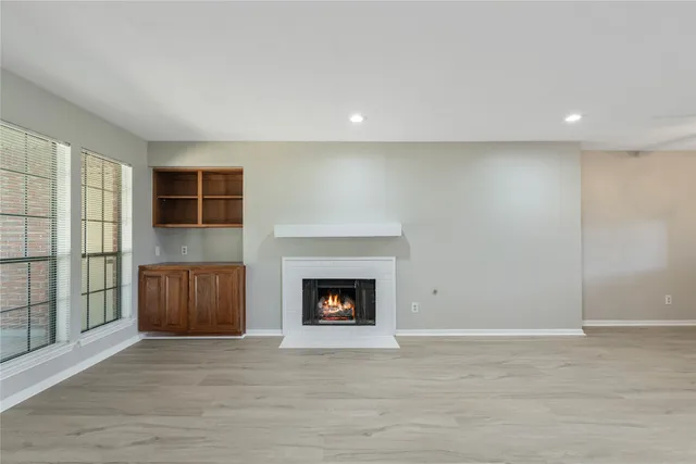 a view of an empty room with a fireplace and a window