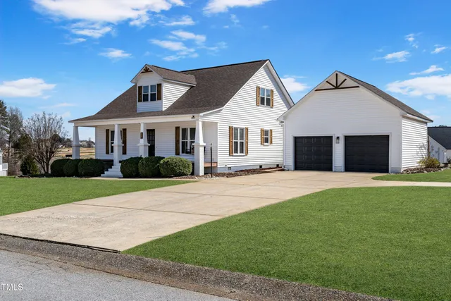 a front view of a house with a garden and yard