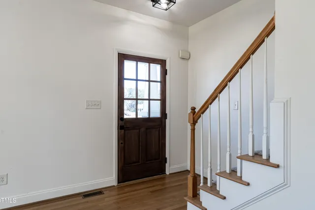 a view of front door with wooden floor and stairs