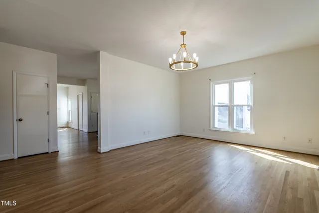 a view of empty room with wooden floor and window