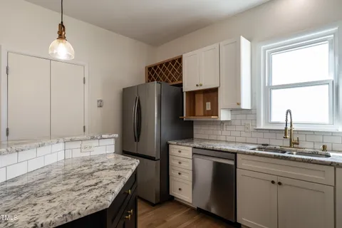 a kitchen with granite countertop cabinets stainless steel appliances and a sink