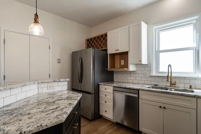 a kitchen with granite countertop cabinets stainless steel appliances and a sink
