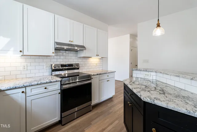 a kitchen with granite countertop cabinets stainless steel appliances and wooden floor