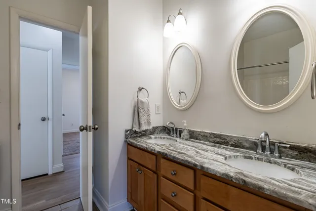 a bathroom with a granite countertop double vanity sinks and a mirror
