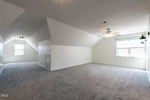 en empty room with windows and chandelier fan