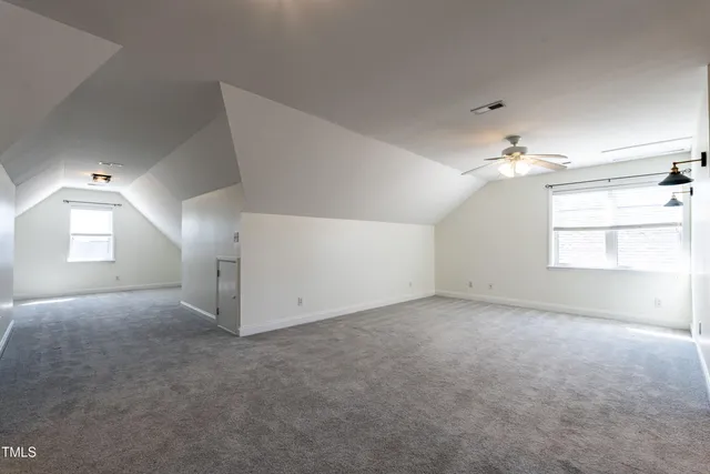 en empty room with windows and chandelier fan