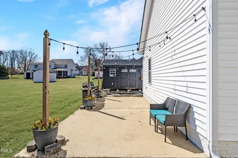 a view of a patio with chairs and potted plants