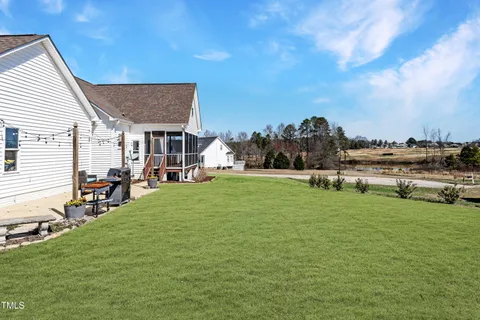 a backyard of a house with table and chairs