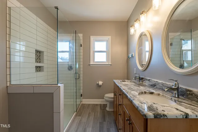 a bathroom with a granite countertop double vanity sink and a mirror