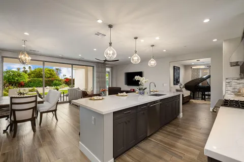 a large kitchen with a counter space a sink appliances and a large window