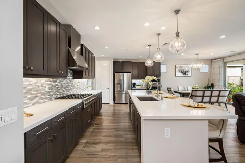 a kitchen with kitchen island granite countertop a sink cabinets and wooden floor