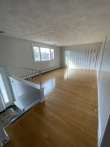 a view of a room with wooden floor staircase and windows